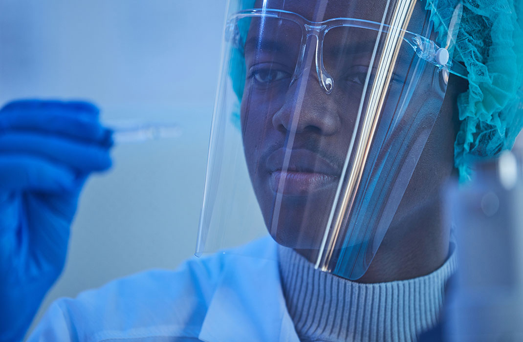 Lab researcher looks at vial